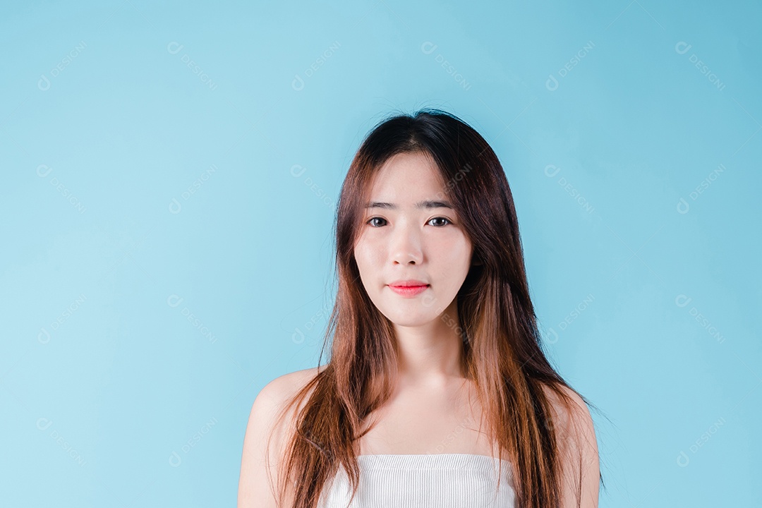 Mulher de beleza asiática encantadora em fundo azul