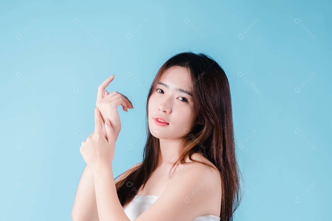 Mulher de beleza asiática encantadora em fundo azul