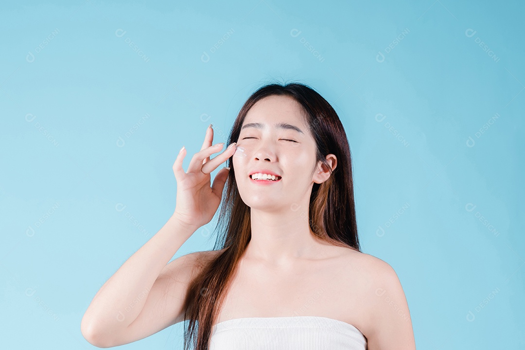 Mulher de beleza asiática aplicando hidratante, loção