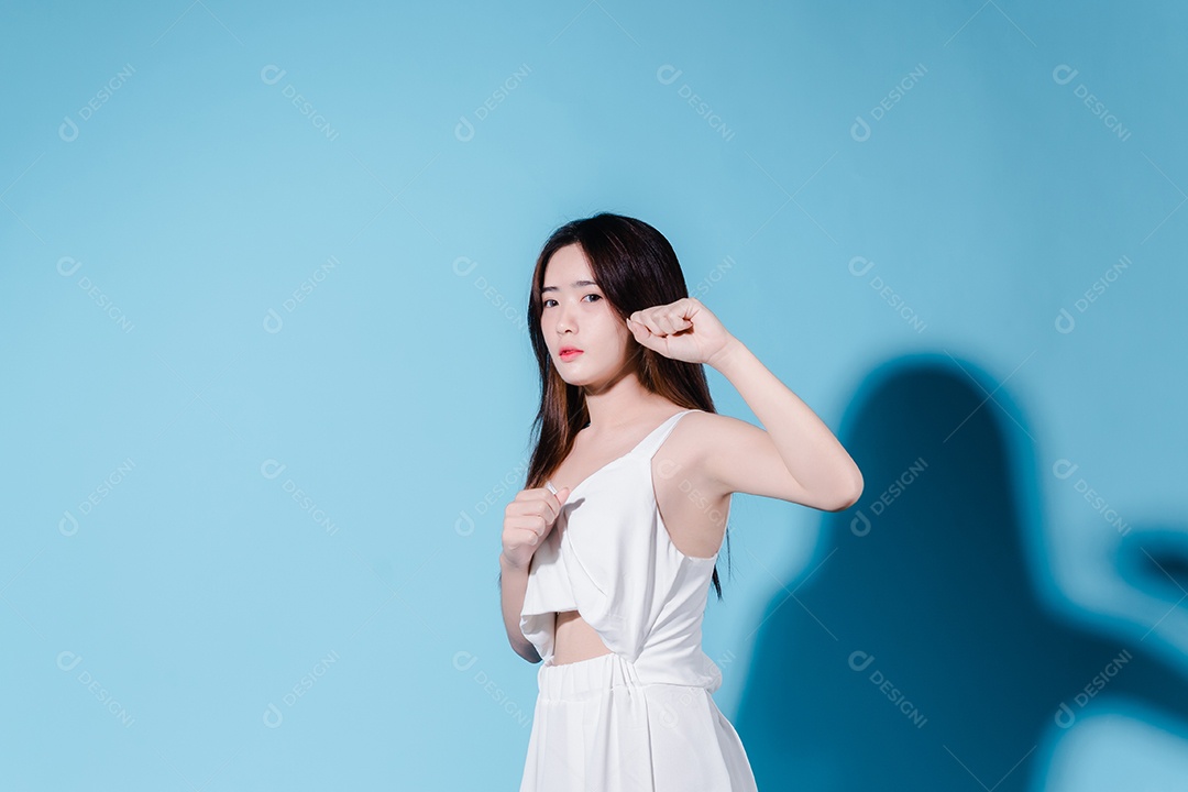 Mulher de beleza asiática encantadora em sessão de fotos com fundo azul