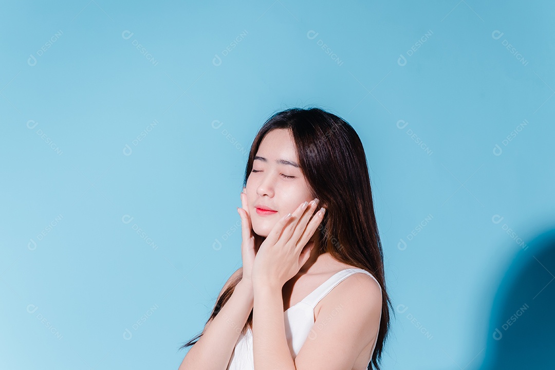 Mulher de beleza asiática encantadora em sessão de fotos com fundo azul