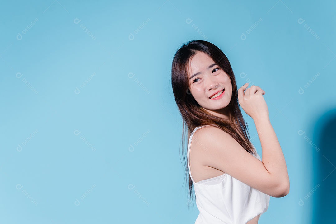 Mulher de beleza asiática encantadora em sessão de fotos com fundo azul