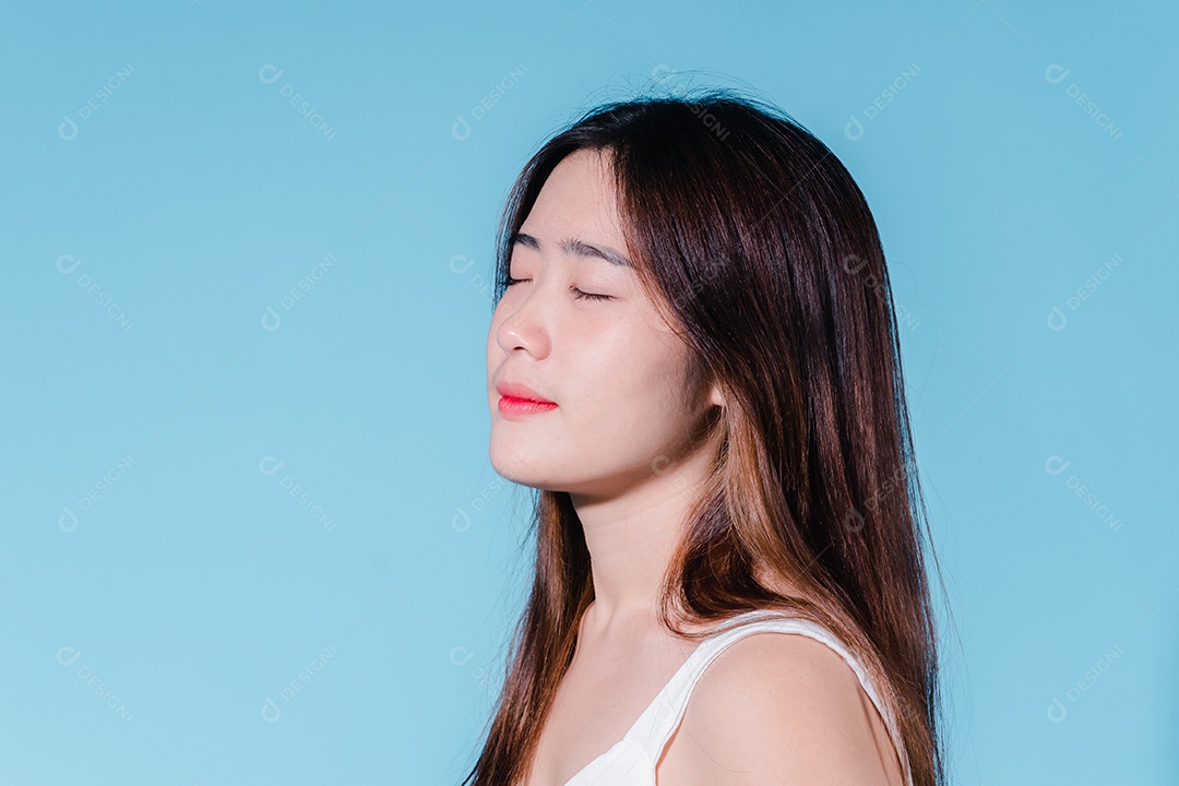 Mulher de beleza asiática encantadora em sessão de fotos com fundo azul