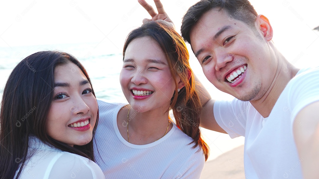 Grupo de jovens amigos tirando selfie na praia