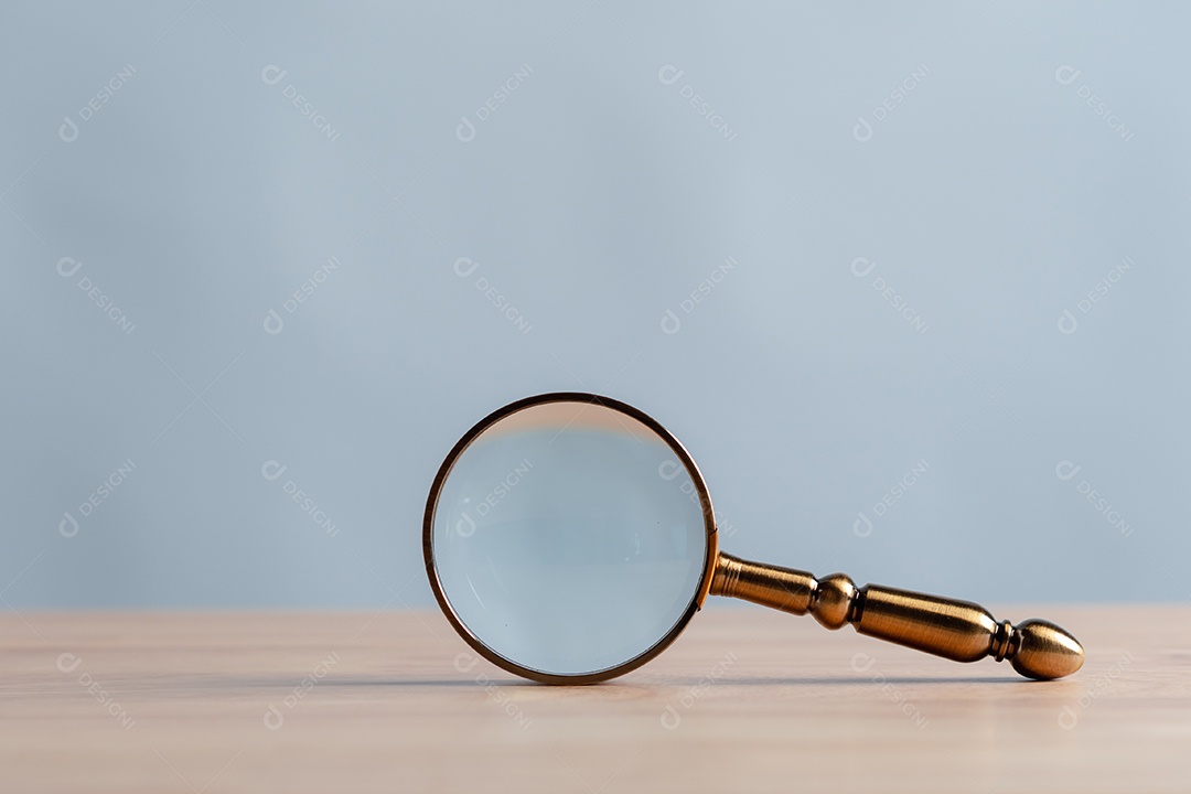 Lupa com detalhes dourados sobre a mesa