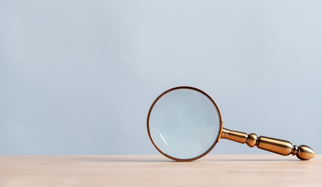 Lupa com detalhes dourados sobre a mesa