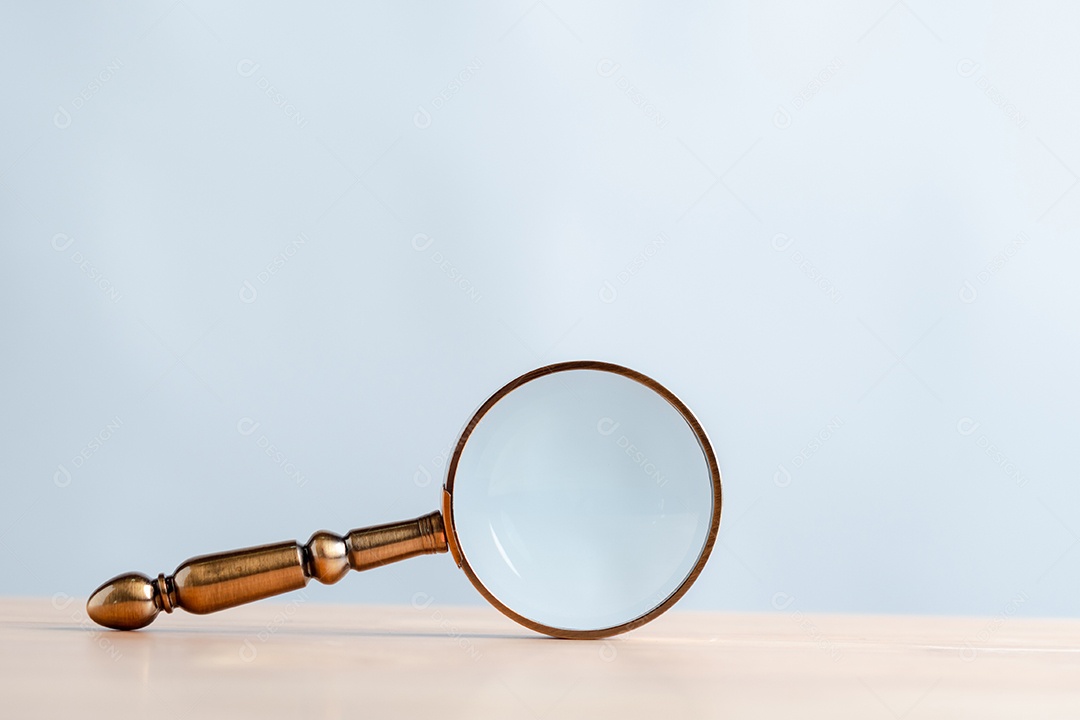 Lupa com detalhes dourados sobre a mesa