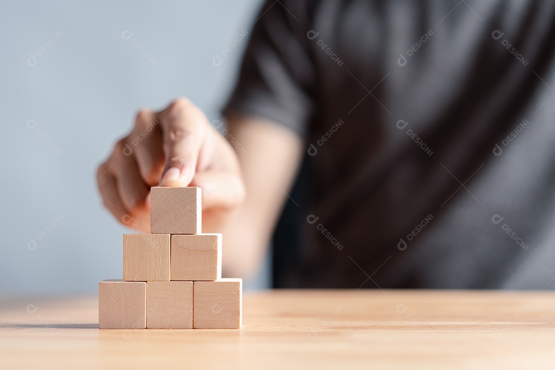 Mão de homem sobre blocos de madeira