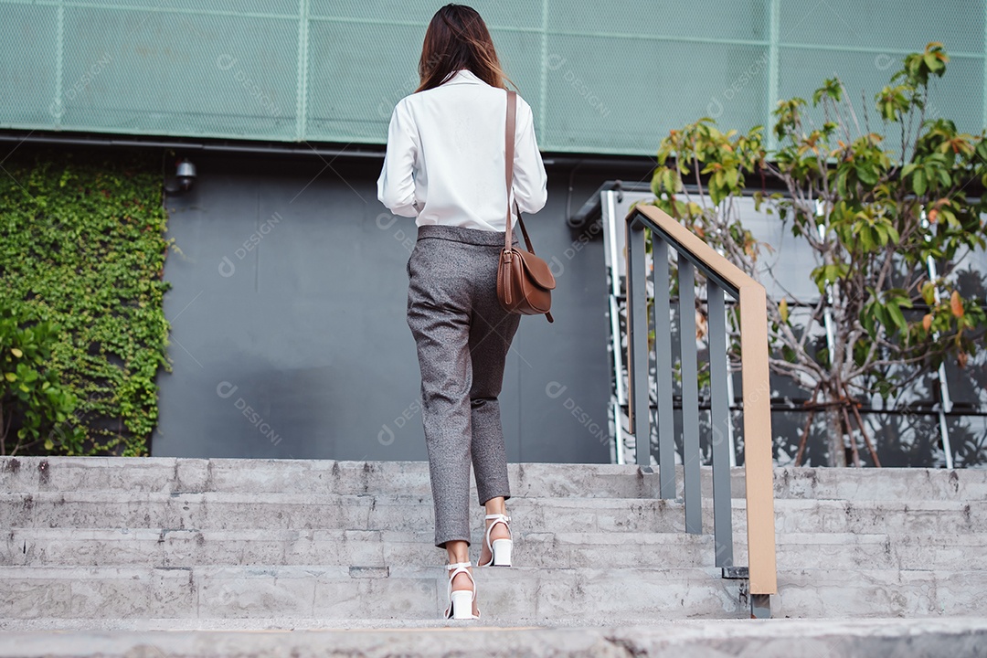 Empresária moderna subindo as escadas da empresa