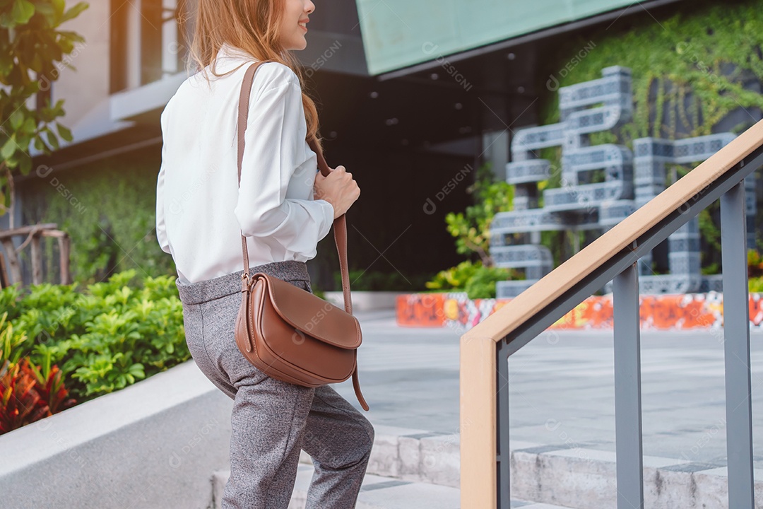Linda empresária elegante subindo as escadas da empresa