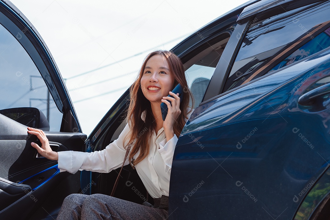 Linda empresária descendo do carro falando ao celular