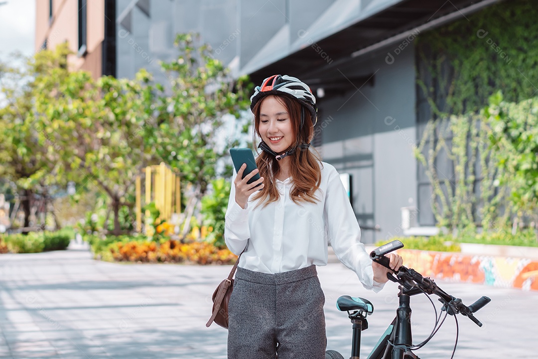 Mulher asiática andando de bicicleta com capacete de segurança