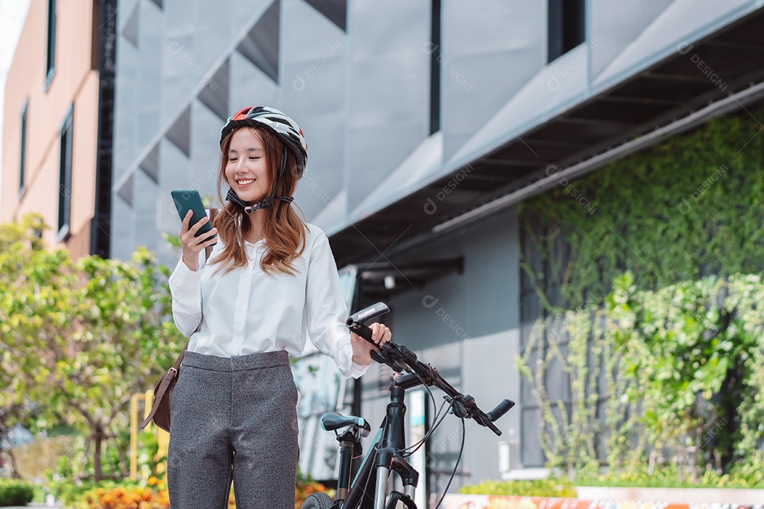 Mulher asiática andando de bicicleta com capacete de segurança