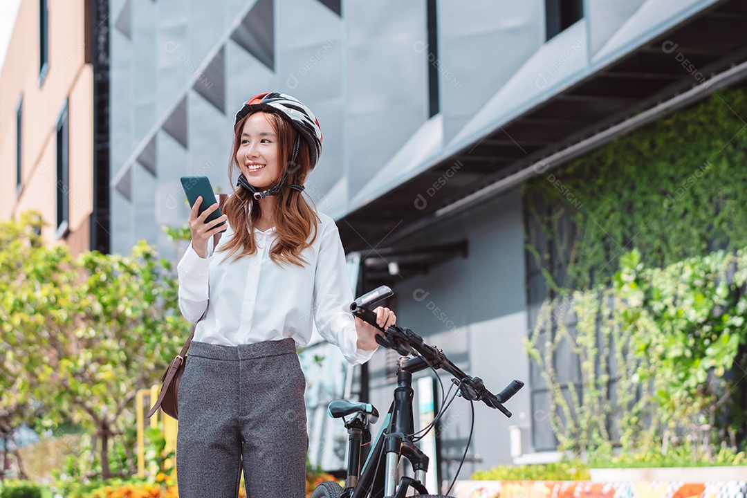 Mulher asiática andando de bicicleta com capacete de segurança