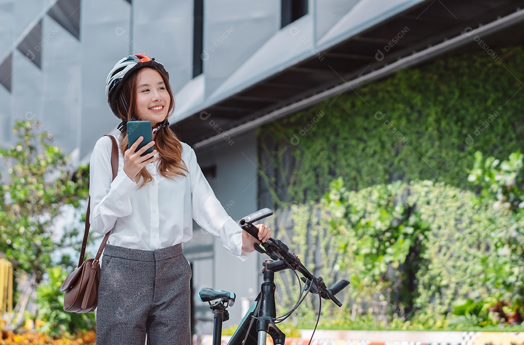 Linda mulher asiática com capacete de segurança andando de bicicleta