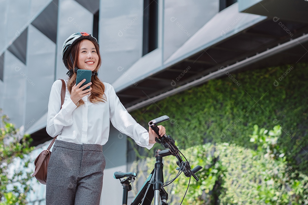 Linda mulher asiática com capacete de segurança andando de bicicleta