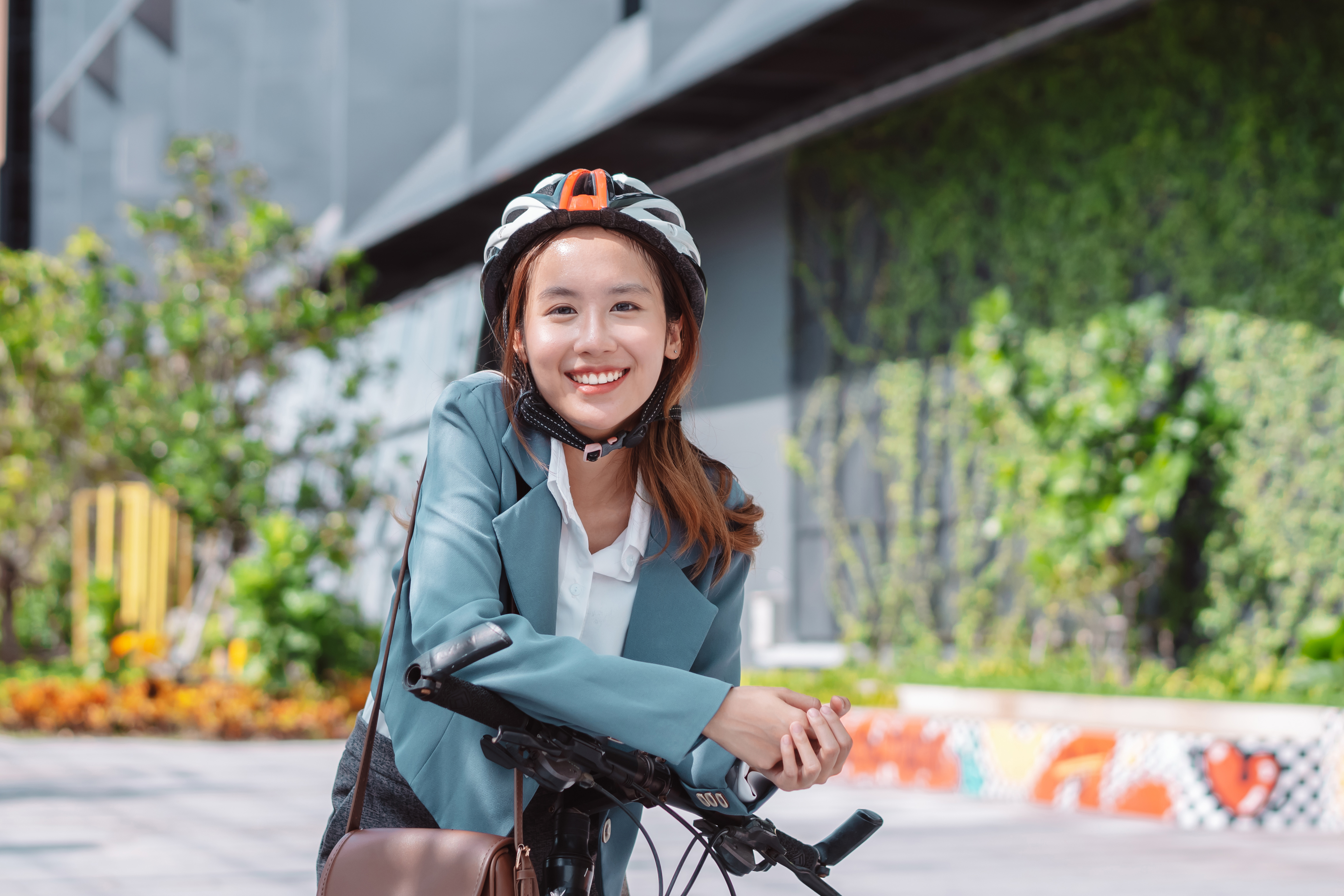 Linda mulher andando de bicicleta com capacete de segurança
