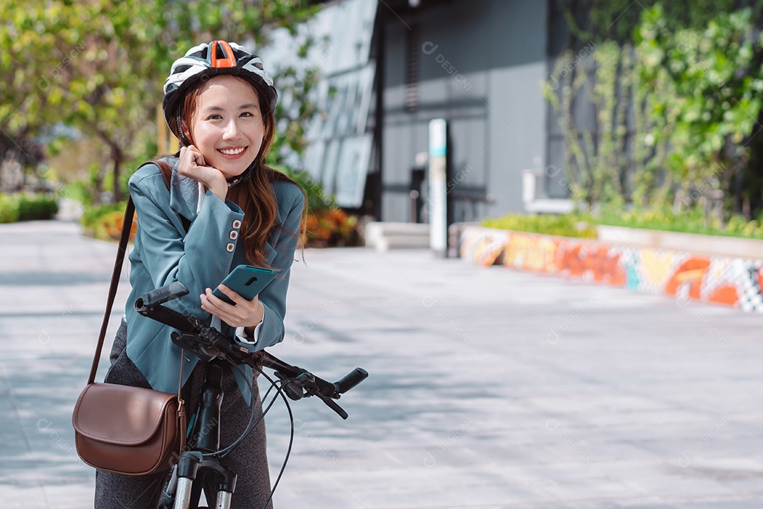 Linda mulher asiática com capacete de segurança andando de bicicleta