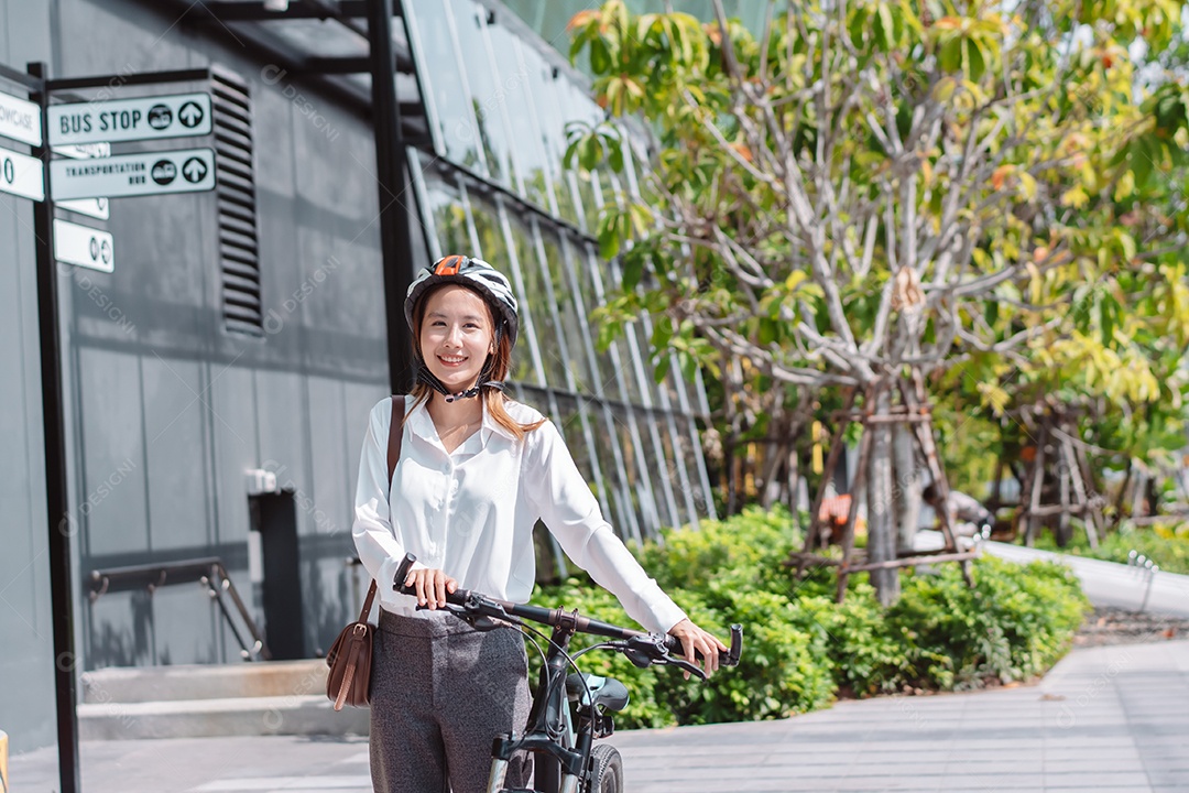 Linda mulher asiática com capacete de segurança andando de bicicleta