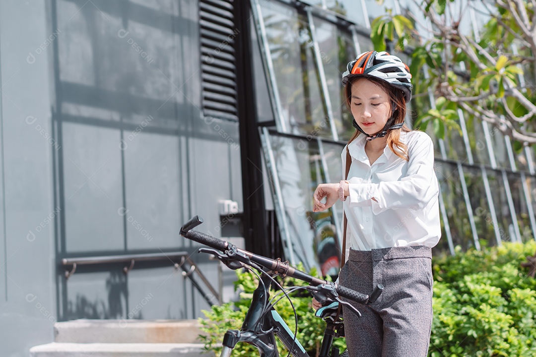Linda mulher asiática com capacete de segurança andando de bicicleta
