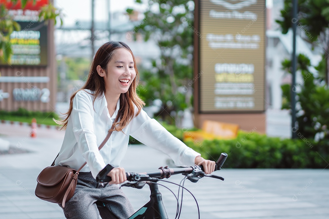 Linda mulher asiática com capacete de segurança andando de bicicleta