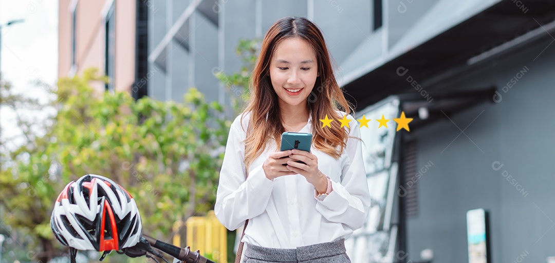 Linda mulher asiática sorridente com bicicleta falando ao celular