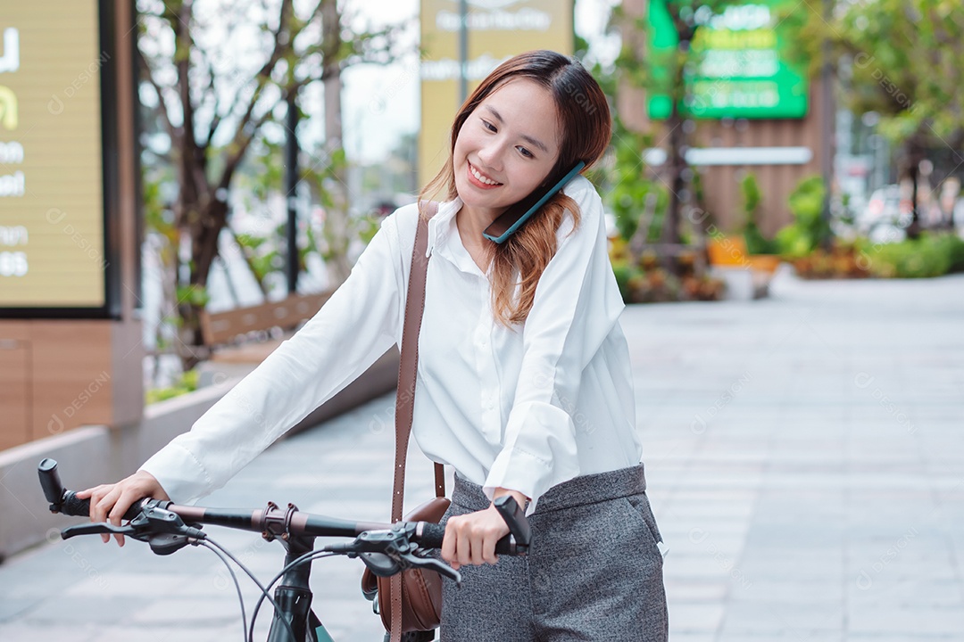 Linda mulher sorridente andando de bicicleta falando ao celular