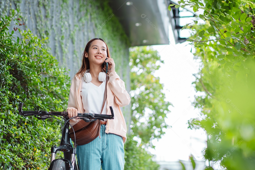 Linda mulher sorridente andando de bicicleta falando ao celular
