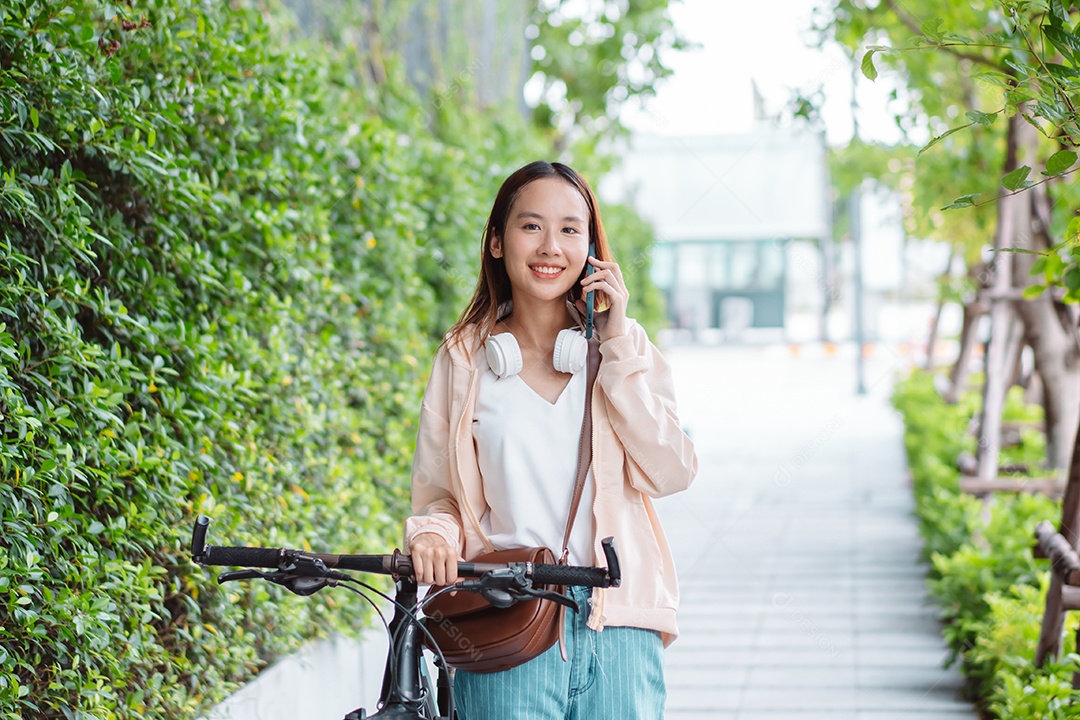 Linda mulher sorridente andando de bicicleta falando ao celular