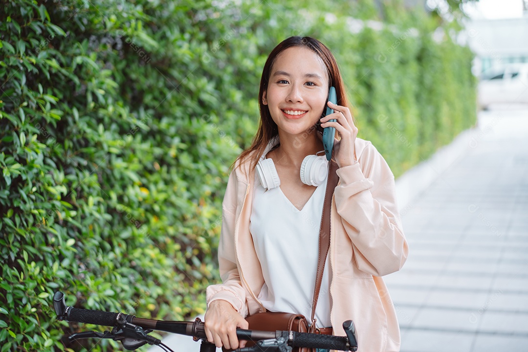 Linda mulher sorridente andando de bicicleta falando ao celular