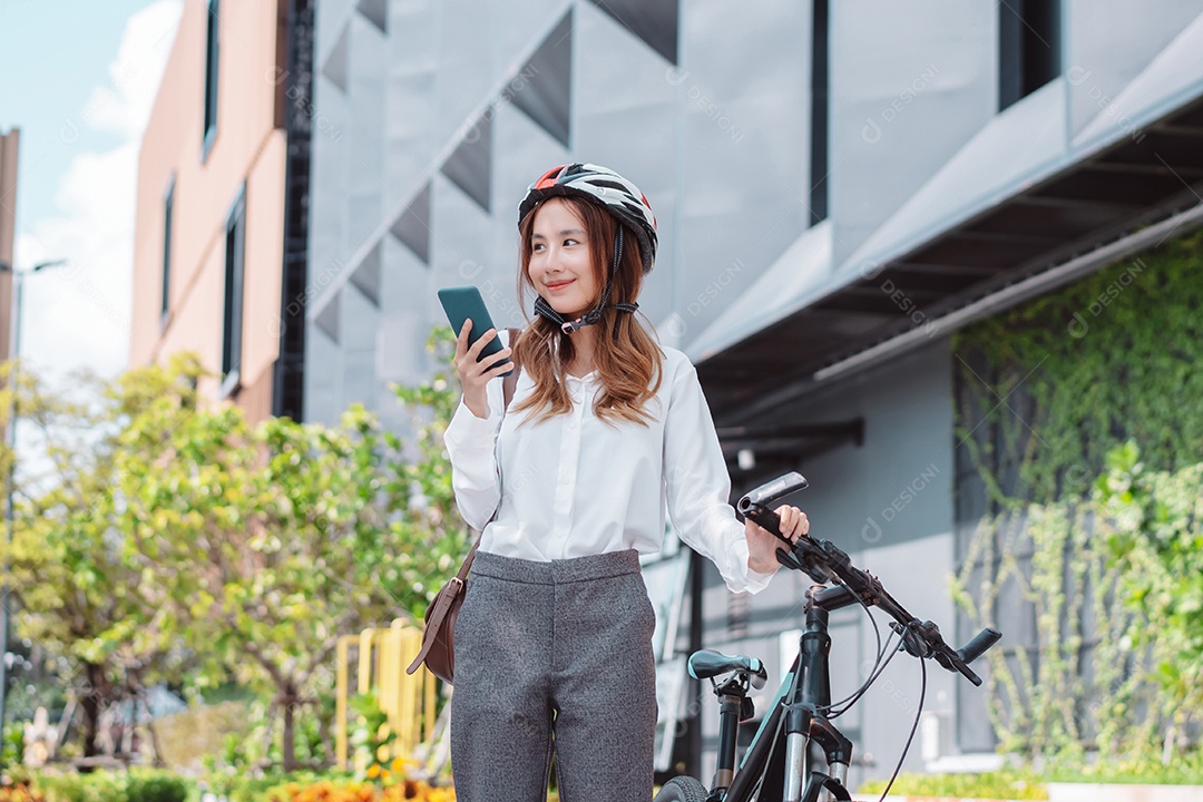 Empresária asiática usando capacete de segurança antes de ir para o trabalho de bicicleta