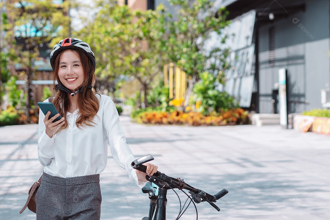 Empresária asiática usando capacete de segurança antes de ir para o trabalho de bicicleta