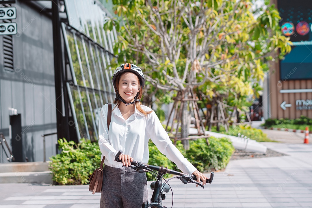 Empresária asiática com capacete andando de bicicleta