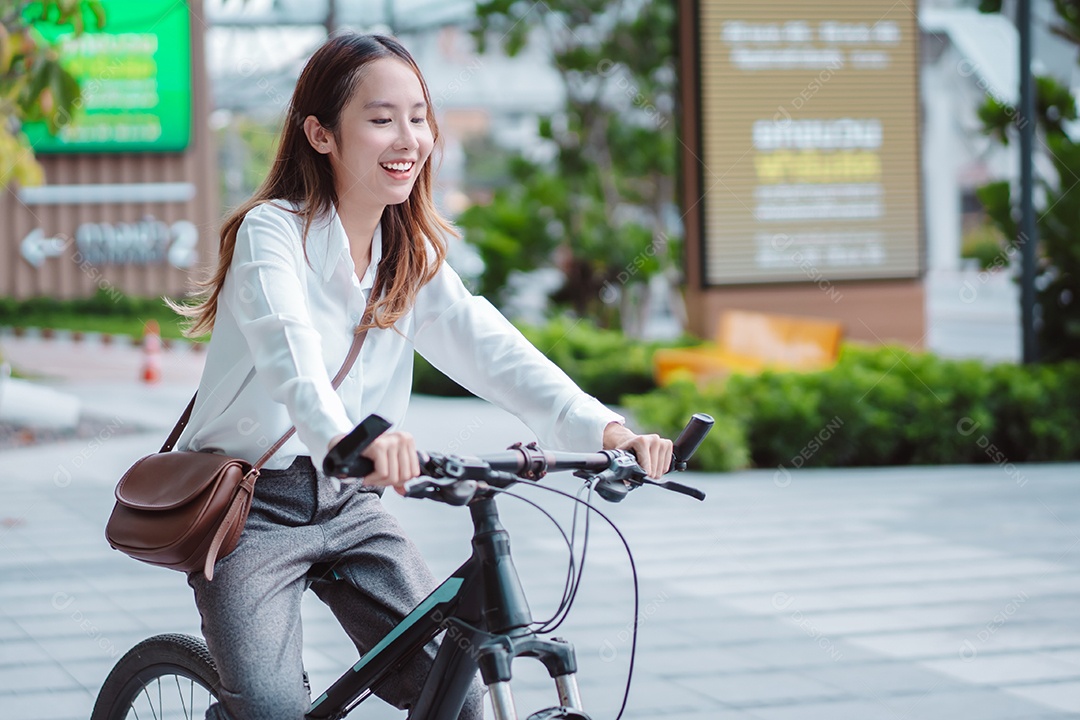 A confiança da empresária asiática vai para o trabalho de escritório na rua da cidade moderna com bicicleta