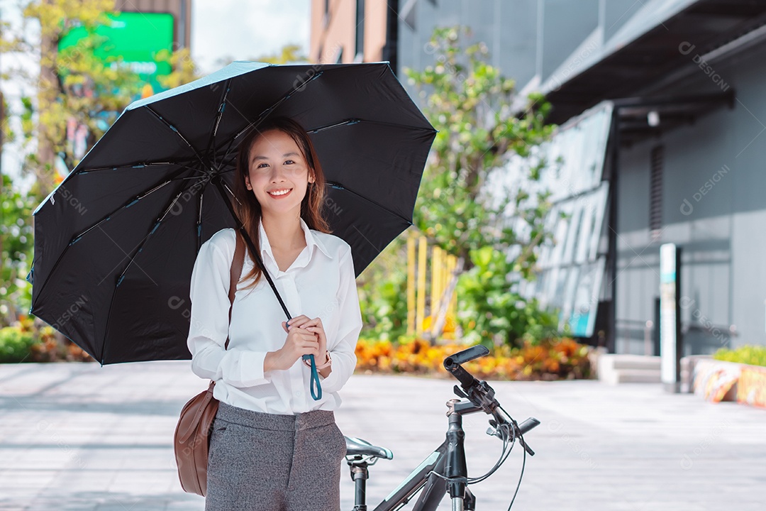 Linda mulher de negócios asiática usa guarda-chuva para proteger