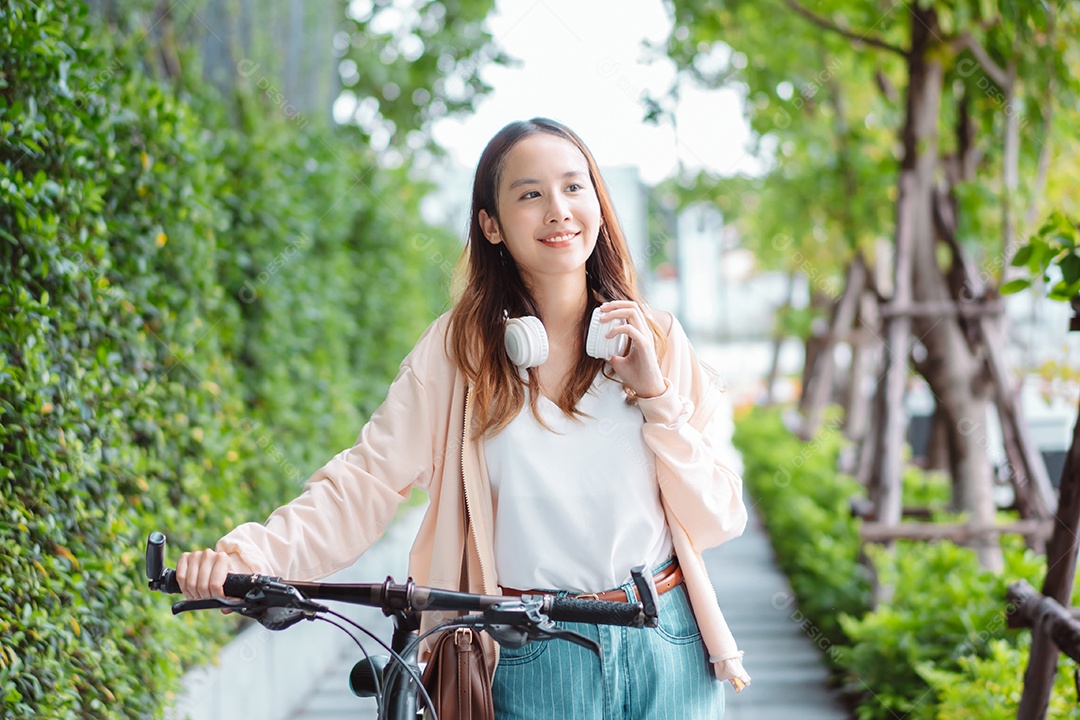 Uma jovem asiática feliz anda de bicicleta no parque