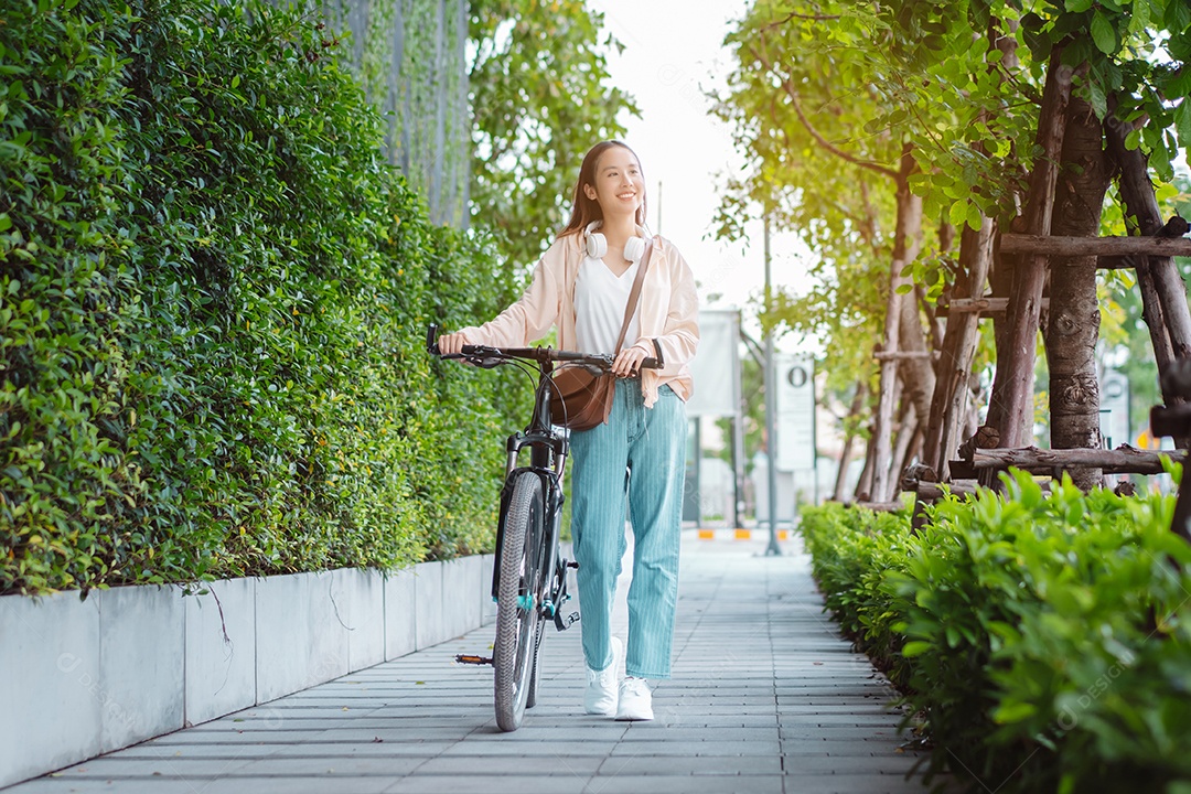 Uma jovem asiática feliz anda de bicicleta no parque