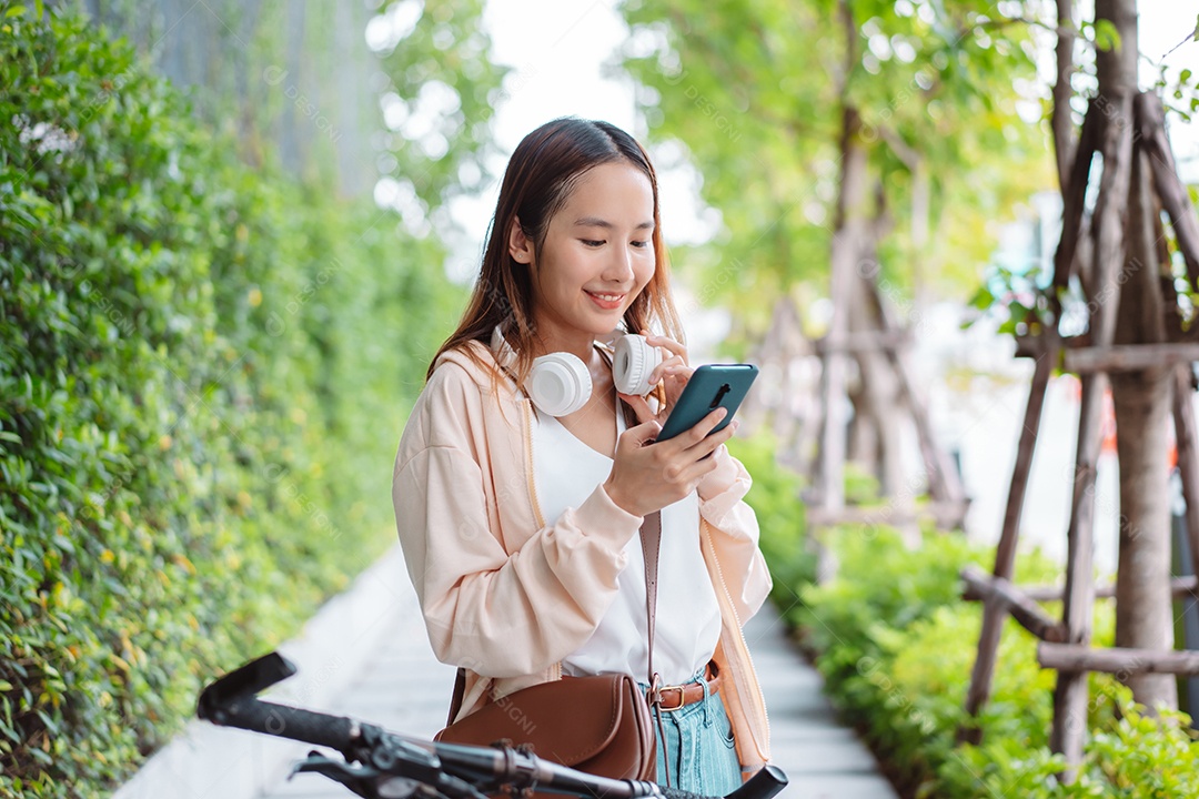 Uma jovem asiática feliz anda de bicicleta no parque