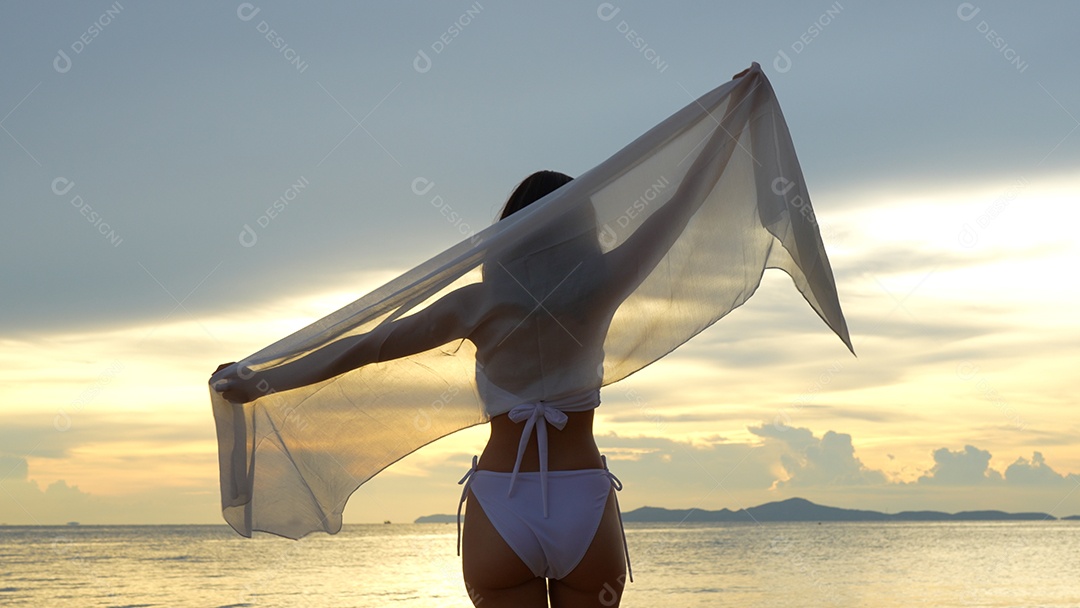 Bela jovem com biquini na praia de férias