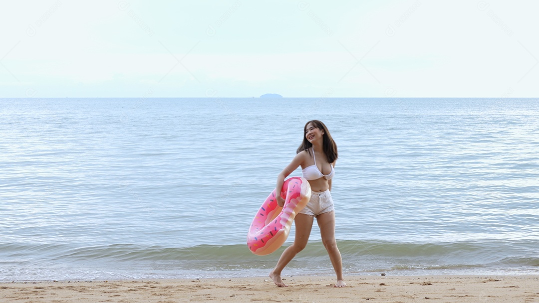 Bela jovem com biquini na praia de férias