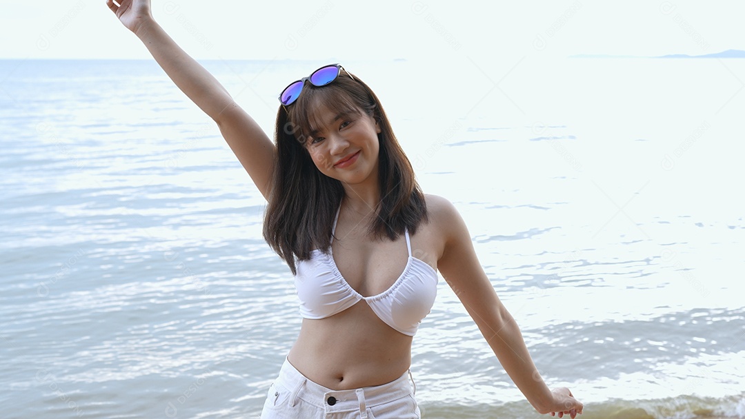 Bela jovem com biquini na praia de férias