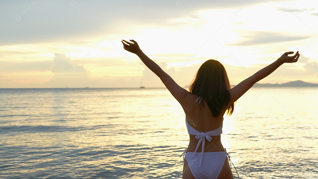 Bela jovem com biquini na praia de férias