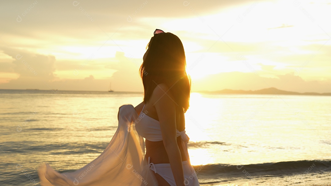 Bela jovem com biquini na praia de férias