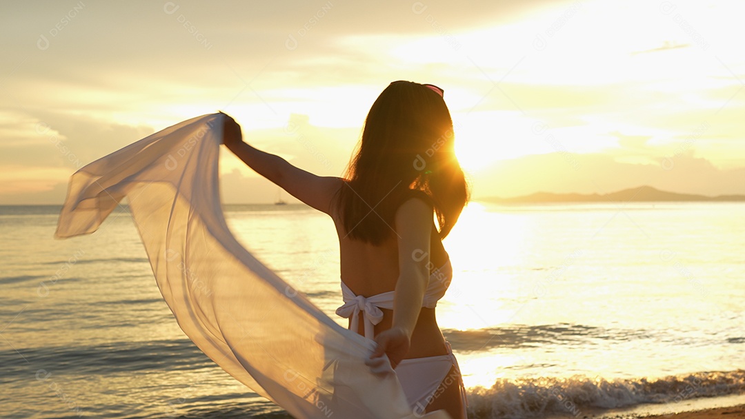 Bela jovem com biquini na praia de férias