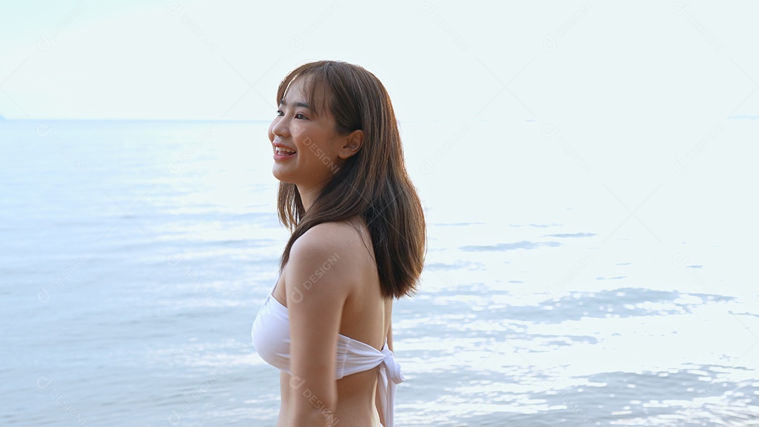 Bela jovem com biquini na praia de férias