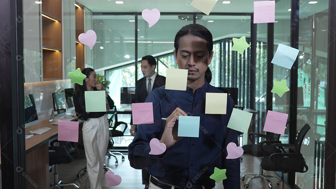 Homem de negócios jovem com brainstorming de trabalho em equipe usando post-its para compartilhar ideias na parede de vidro
