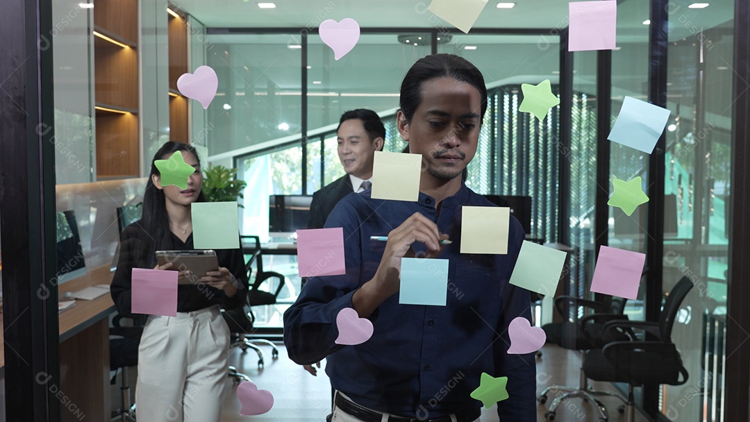 Funcionários escrevendo pequenos lembretes e colando sobre vidro