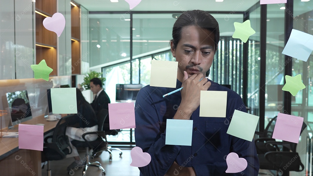 Homem escrevendo pequenos lembretes e colando sobre vidro