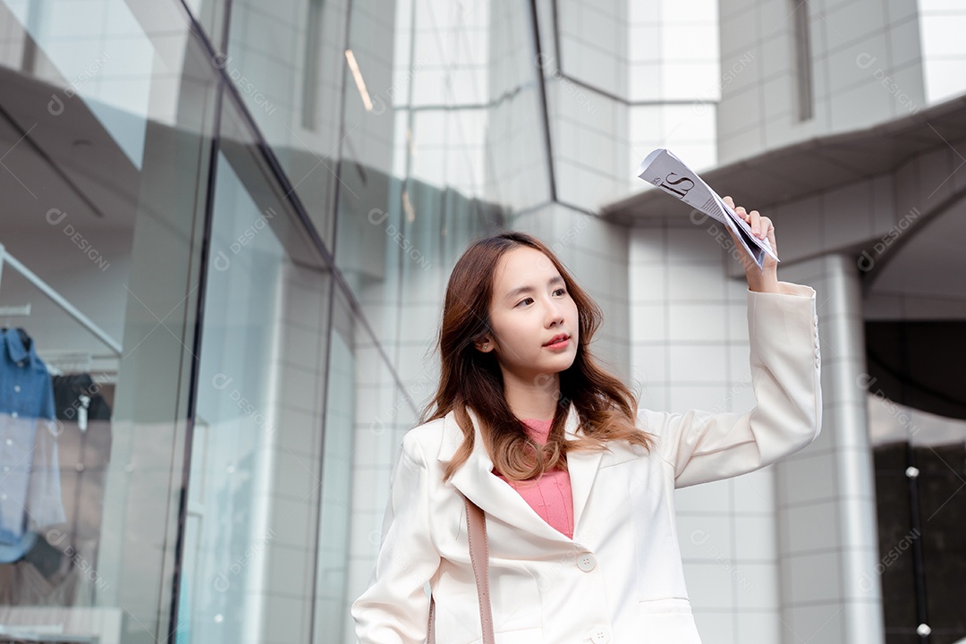 A emoção de estresse da empresária asiática pega o jornal cobre o rosto