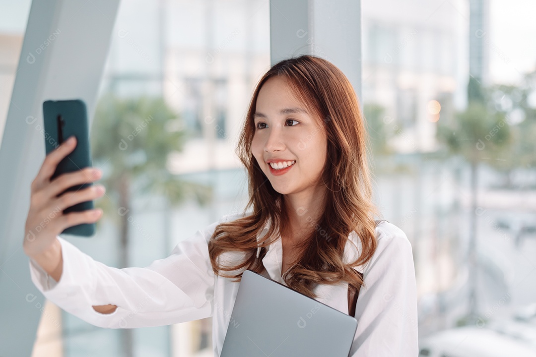 Linda empresária asiática segura laptop,